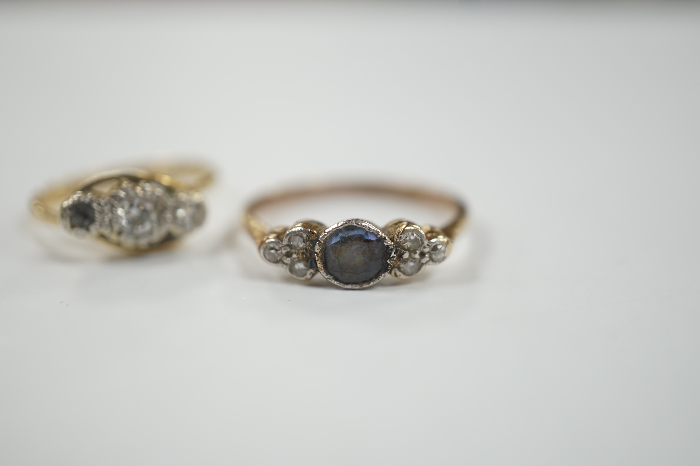 A 1920's/1930's 18ct and plat. single stone sapphire and six stone diamond set dress ring, size P/Q, together with an 18ct, plat and two (ex three) stone diamond set crossover ring, gross weight 5.4 grams.